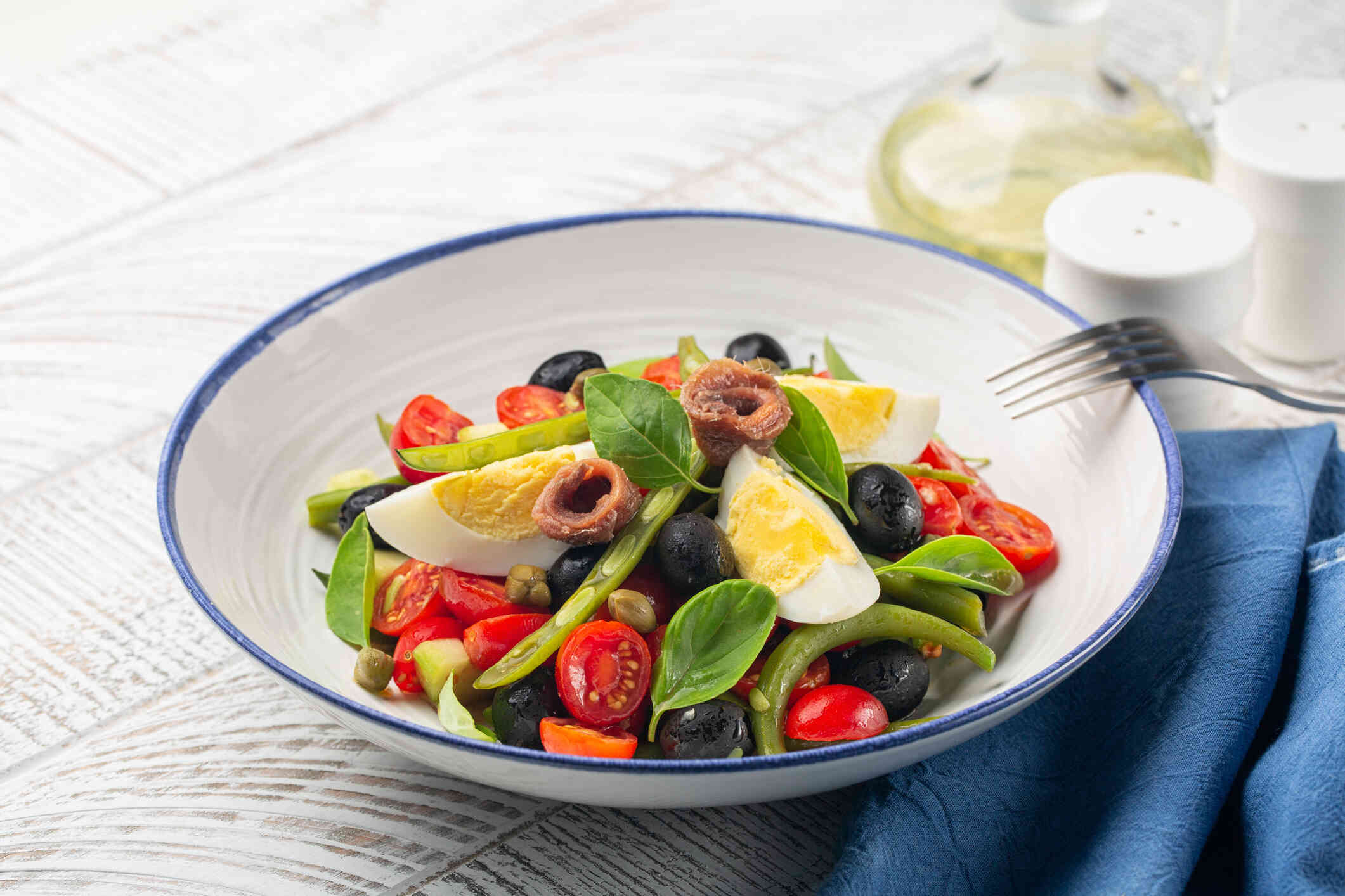 A close up of a colorful salad in a bowl, sitting on a table.