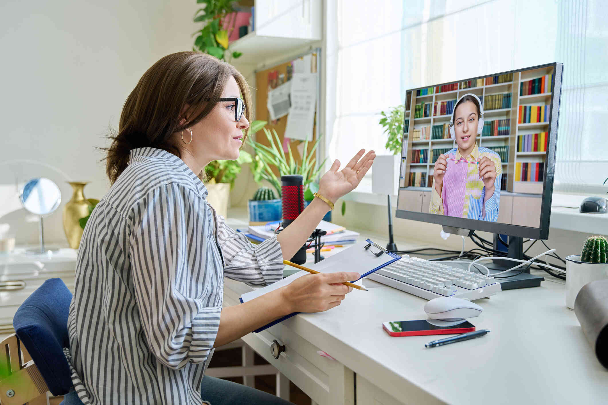 A teenage girl appears on a computer screen, engaged in an online therapy session.