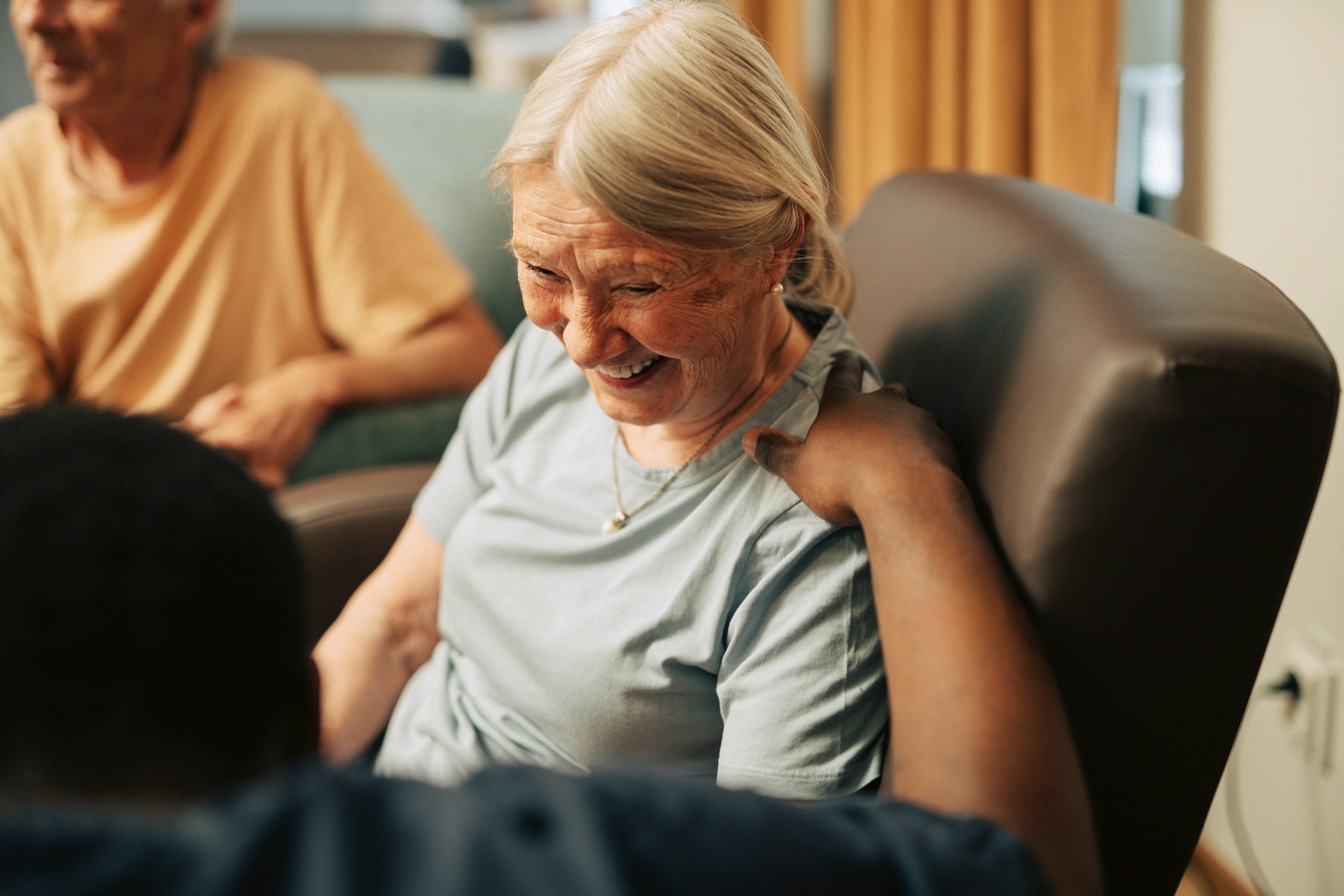 An older white woman receives attentive care and support from a caretaker. BetterHelp's online therapy helps older adults and caregivers manage emotional well-being and mental health challenges.