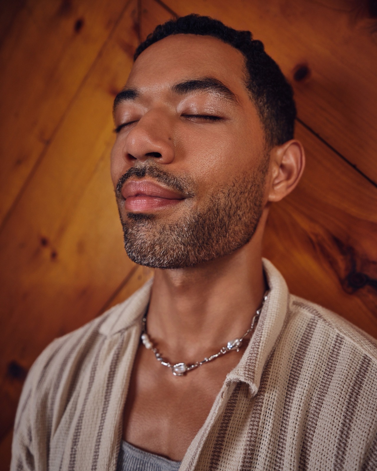 A calm and composed Black man in his late 30s poses for a portrait with a steady gaze. BetterHelp offers personalized online therapy for adults navigating life's challenges and mental health needs.
