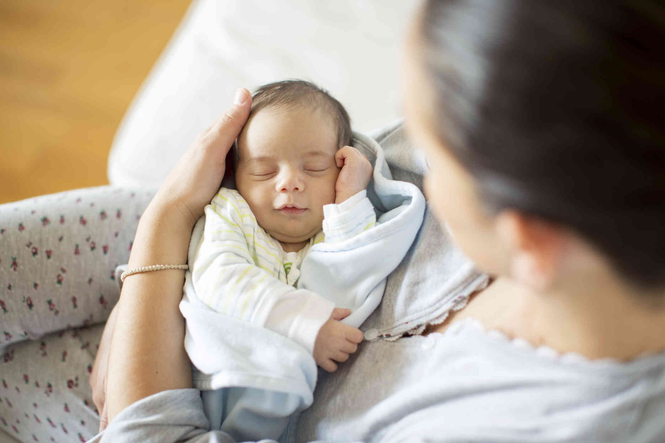 A close up of a mother holding her newborn baby in her arms.