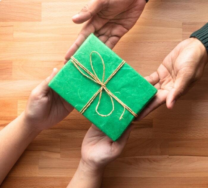 Hands presenting a wrapped gift box
